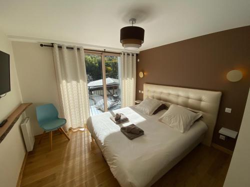 une chambre avec un lit, une chaise et une fenêtre dans l'établissement Le Clos Casi - 3 Vallées - Ski - Cures thermales, à Brides-les-Bains