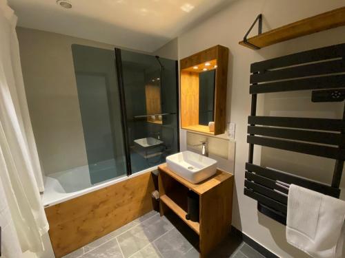 une salle de bain avec un lavabo et une baignoire dans l'établissement Le Clos Casi - 3 Vallées - Ski - Cures thermales, à Brides-les-Bains