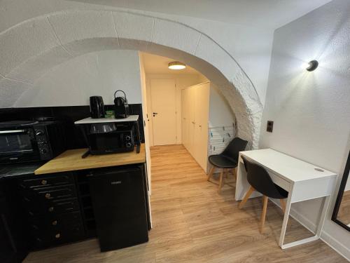 - une cuisine avec une arche, une table et des chaises dans l'établissement Charmant studio climatisé à 200m de la plage, à Mèze