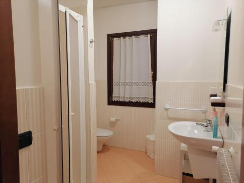 a white bathroom with a toilet and a sink at Agriturismo Il Salice Ridente in Pasiano di Pordenone