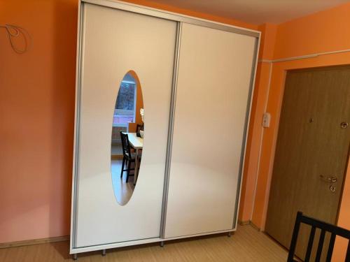 un grande armadio bianco con finestra circolare in una stanza di Orsy House a Făgăraş
