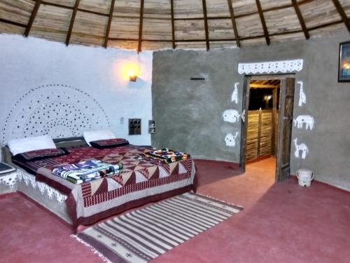 a bedroom with a large bed in a room at Shilpgram in Bhuj