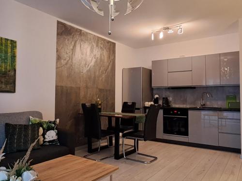 a living room with a table and a kitchen at Apartament-Sweet Night in Lubin