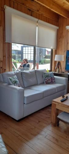 un hombre sentado en un sofá en una sala de estar en Condominio Don Alberto, en Pichilemu