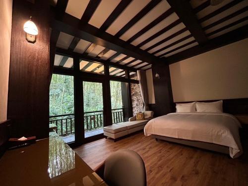 a bedroom with a bed and a large window at 日月潭森堡萊夫莊園 in Yuchi
