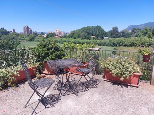 un patio con tavolo, sedie e piante in vaso di Frantoio Pistelli a Terni