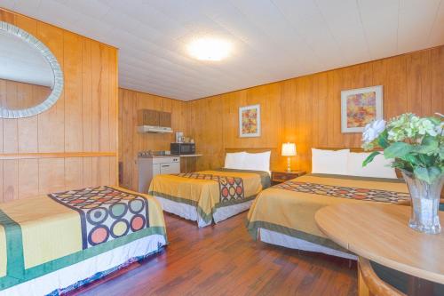 a hotel room with two beds and a table at Parkside Motel by OYO Meadville Conneaut Lake in Conneaut Lake Park