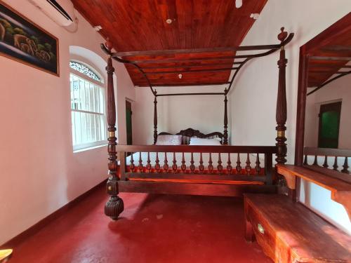 a bedroom with a large wooden bed in a room at Hill Side Kings Villa (Colonial Bungalow) in Hikkaduwa