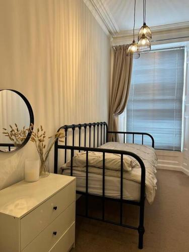 a bedroom with a bed and a mirror and a dresser at Swn Y Mor 4 Aberystwyth in Aberystwyth