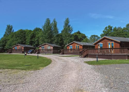 a gravel road in front of a row of houses at Nethercraig Holiday Park in Alyth