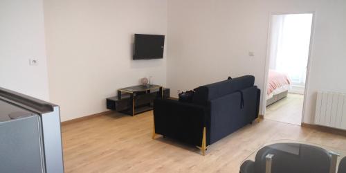 a living room with a black couch and a bed at Le voyageur - T2 hyper centre in Abbeville