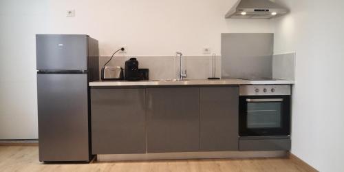 une cuisine avec un évier et un réfrigérateur dans l'établissement Le voyageur - T2 hyper centre, à Abbeville