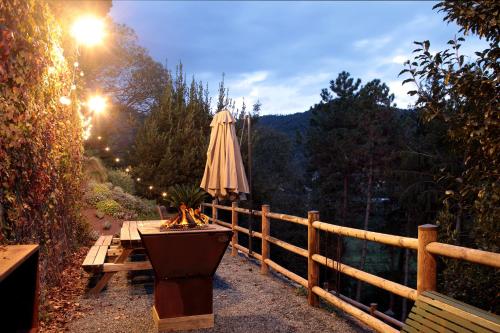 a table with an umbrella next to a fence at Villa Lucini 1886 "La Dolcevita" Cottage 2, close to Lake Como and Milan in Calco