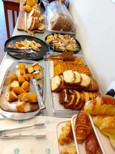 a table filled with different types of bread and pastries at Alexandros Studios in Kalamaki Chanion