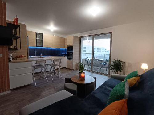 sala de estar con sofá azul y cocina en Chambre dans un joli appartement cosy, en Burdeos