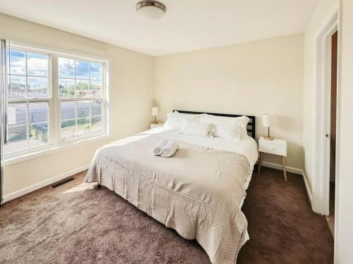 - une chambre blanche avec un grand lit et une fenêtre dans l'établissement Luxury & Style, 3 King Bed, W/D, & FREE Garage, à Schenectady
