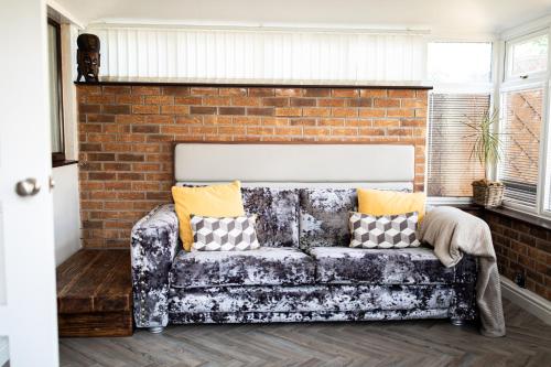 a couch in a room with a brick wall at Inviting 3-Bed House in Manchester in Manchester