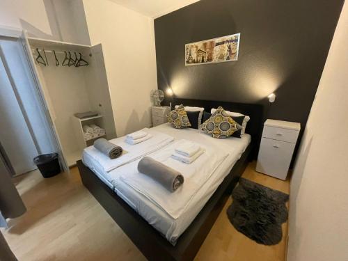Un dormitorio con una cama con sábanas y almohadas blancas. en City West Studios, en Stuttgart