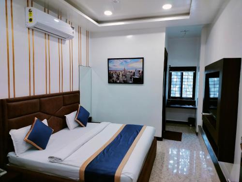 a bedroom with a large bed with blue pillows at Hotel Om in Betūl