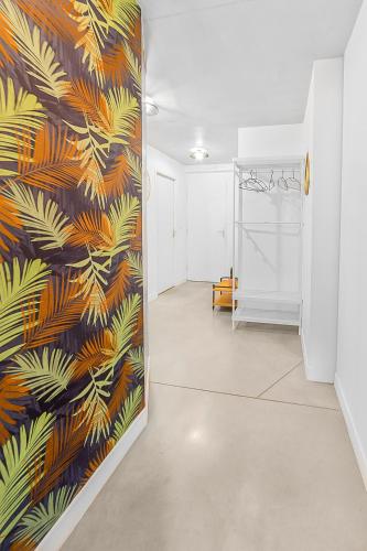 un couloir orné d'une fresque murale représentant des feuilles de palmier dans l'établissement Le Domaine de Fromiga, à Lattes