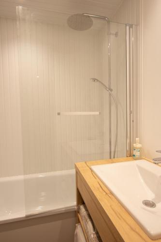 une salle de bain avec une douche, un lavabo et une baignoire dans l'établissement Tignes - Beau studio pied pistes, à Tignes