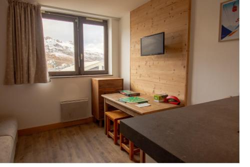 Cette chambre comprend une table et une télévision. dans l'établissement Tignes - Beau studio pied pistes, à Tignes