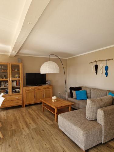 a living room with a couch and a table at Ferienwohnung Sort Sol Grellsbülldeich 7 in Aventoft