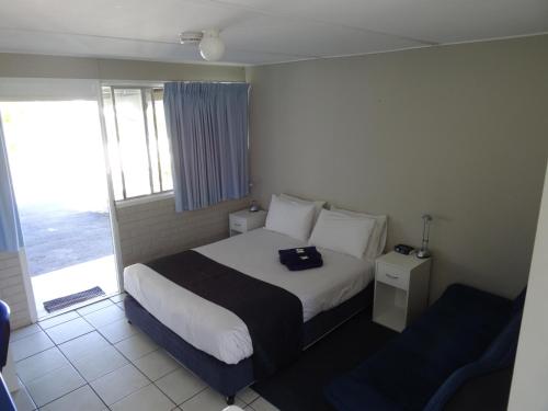 a hotel room with a bed and a window at Chinderah Motel in Chinderah