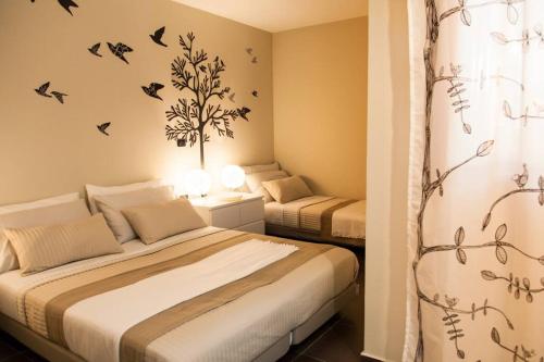 twee bedden in een slaapkamer met vogels aan de muur bij Villa Salvo in Balestrate