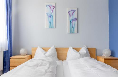 a bedroom with two beds and two paintings on the wall at Wohlfühlwelt Riegler in Allentsteig