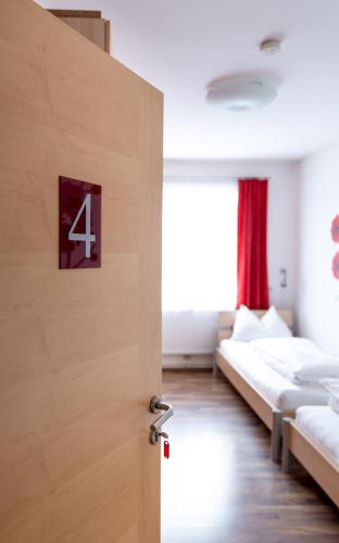 a room with two beds and a door with the number four at Wohlfühlwelt Riegler in Allentsteig