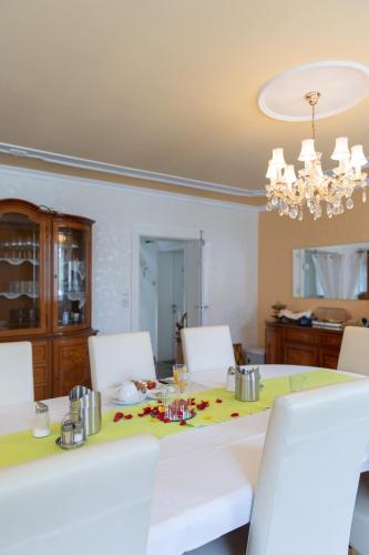 a dining room table with white chairs and a chandelier at Wohlfühlwelt Riegler in Allentsteig