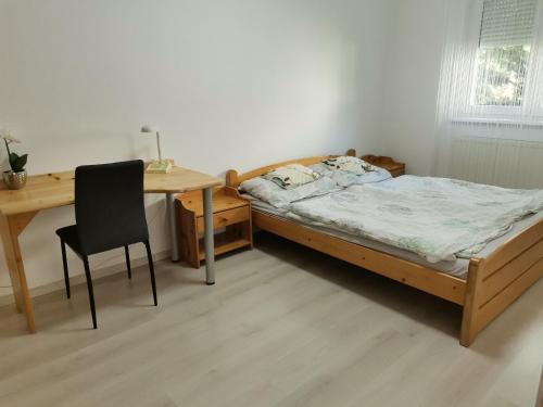 a bedroom with a bed and a desk and a chair at OASIS APARTMAN II. in Szeged