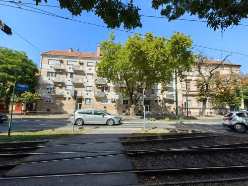 two cars parked in a parking lot in front of a building at OASIS APARTMAN II. in Szeged