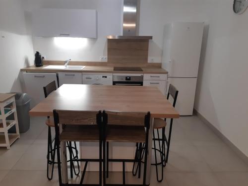 une cuisine avec une table en bois et un réfrigérateur dans l'établissement Appartement Proche du Port de Bonifacio, à Bonifacio