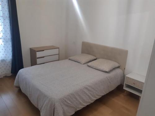 une petite chambre avec un lit et une table de chevet dans l'établissement Appartement Proche du Port de Bonifacio, à Bonifacio