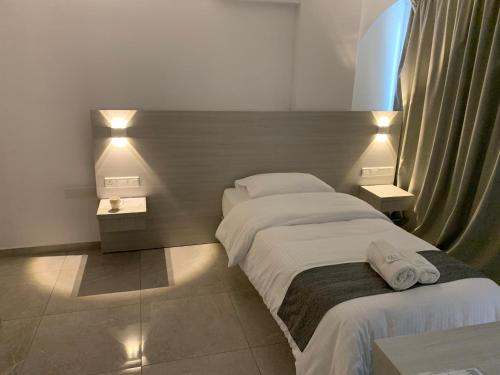 ein Hotelzimmer mit 2 Betten und Handtüchern darauf in der Unterkunft La Veranda Hotel in Larnaka