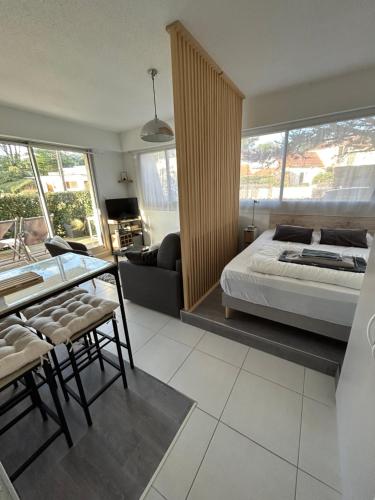 een slaapkamer met een bed en een woonkamer bij LA BAULE : STUDIO MER EN REZ DE JARDIN in La Baule