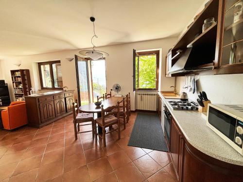 a kitchen with a table and a dining room at Incanto Nesso Parking and Lake View in Nesso