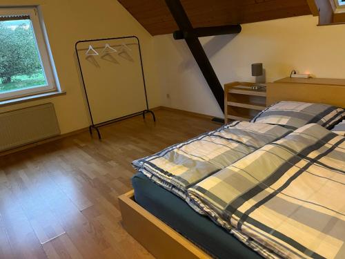 Schlafzimmer mit einem Bett und einem Fenster in der Unterkunft Ferienwohnung auf dem Land und trotzdem stadtnah. in Herford