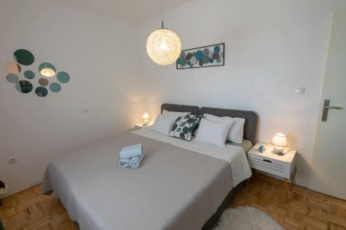 本科瓦茨的住宿－Kuća za odmor M&J，卧室配有一张白色大床和两盏灯。