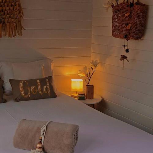 ein Bett mit einem Kissen und einer Lampe auf einem Tisch in der Unterkunft Cabane Charme & Jacuzzi in La Plaine