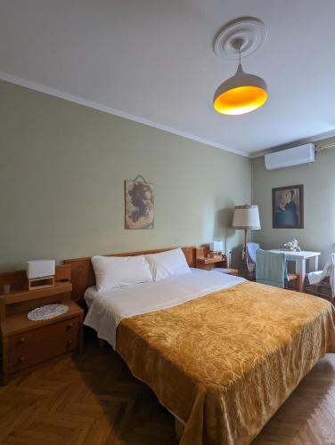 ein Schlafzimmer mit einem großen Bett und einem Tisch in der Unterkunft Scanderbeg Square Apartment in Tirana