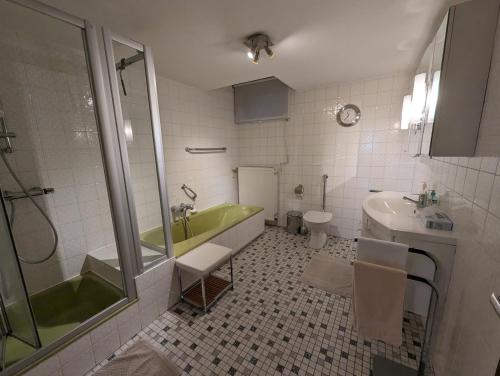 a bathroom with a green tub and a sink at Ferienwohnung Karin in Schotten