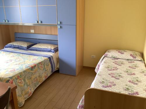 Habitación pequeña con 2 camas y armario en Oasi Mare, en Numana