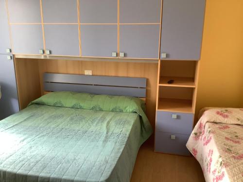 um pequeno quarto com uma cama e um armário em Oasi Mare em Numana