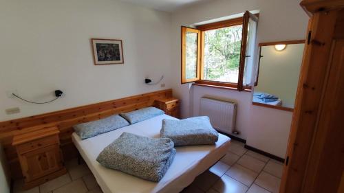 ein Schlafzimmer mit einem Bett mit zwei Kissen darauf in der Unterkunft Appartamenti Vacanze Lagolo in Lagolo di Calavino