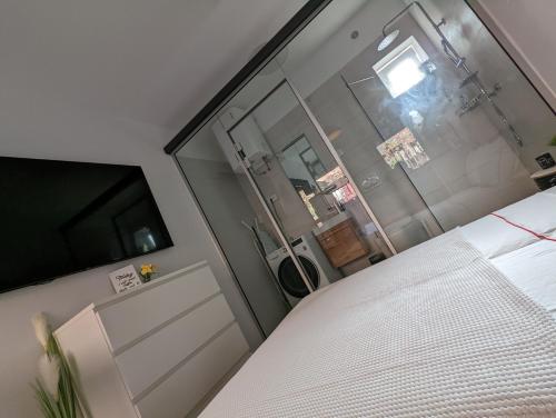 - une chambre avec un lit blanc et une fenêtre dans l'établissement Cozy Maksimir Condo w Washer-Dryer & 65'' TV, à Zagreb