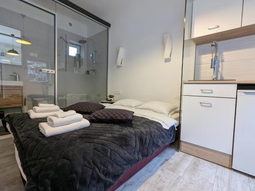 - une chambre avec un grand lit et des serviettes dans l'établissement Cozy Maksimir Condo w Washer-Dryer & 65'' TV, à Zagreb