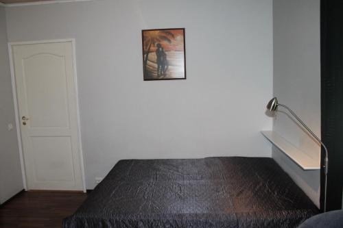 Habitación con cama y una foto en la pared. en Oulunsalo Apartment, en Oulunsalo